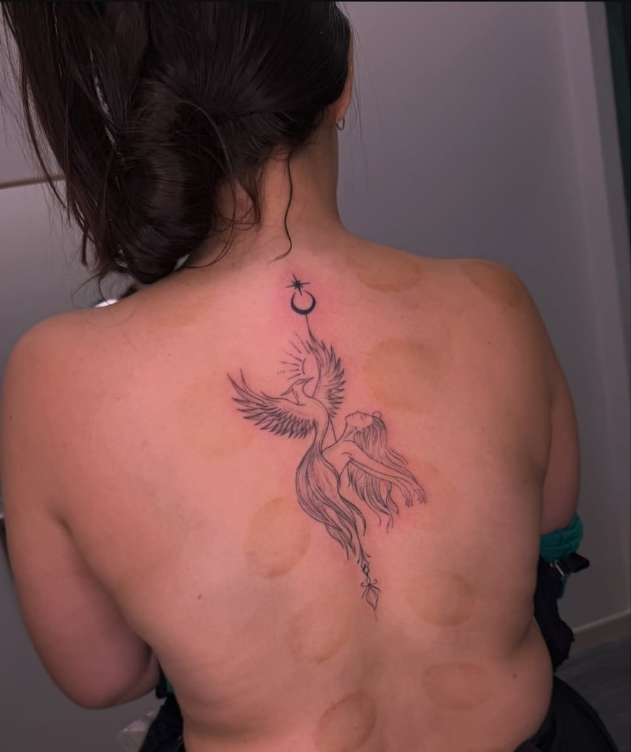 Tatuagem fine line de fênix e mulher nas costas